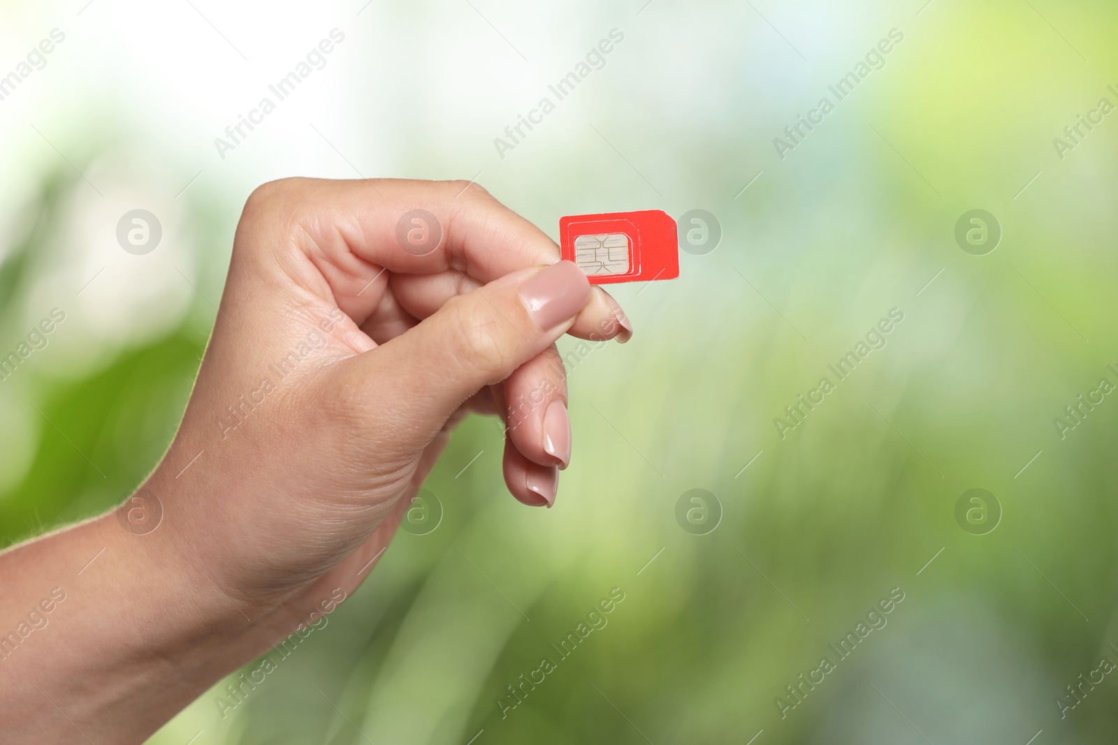 Photo of Woman with SIM card against blurred green background, closeup, Space for text