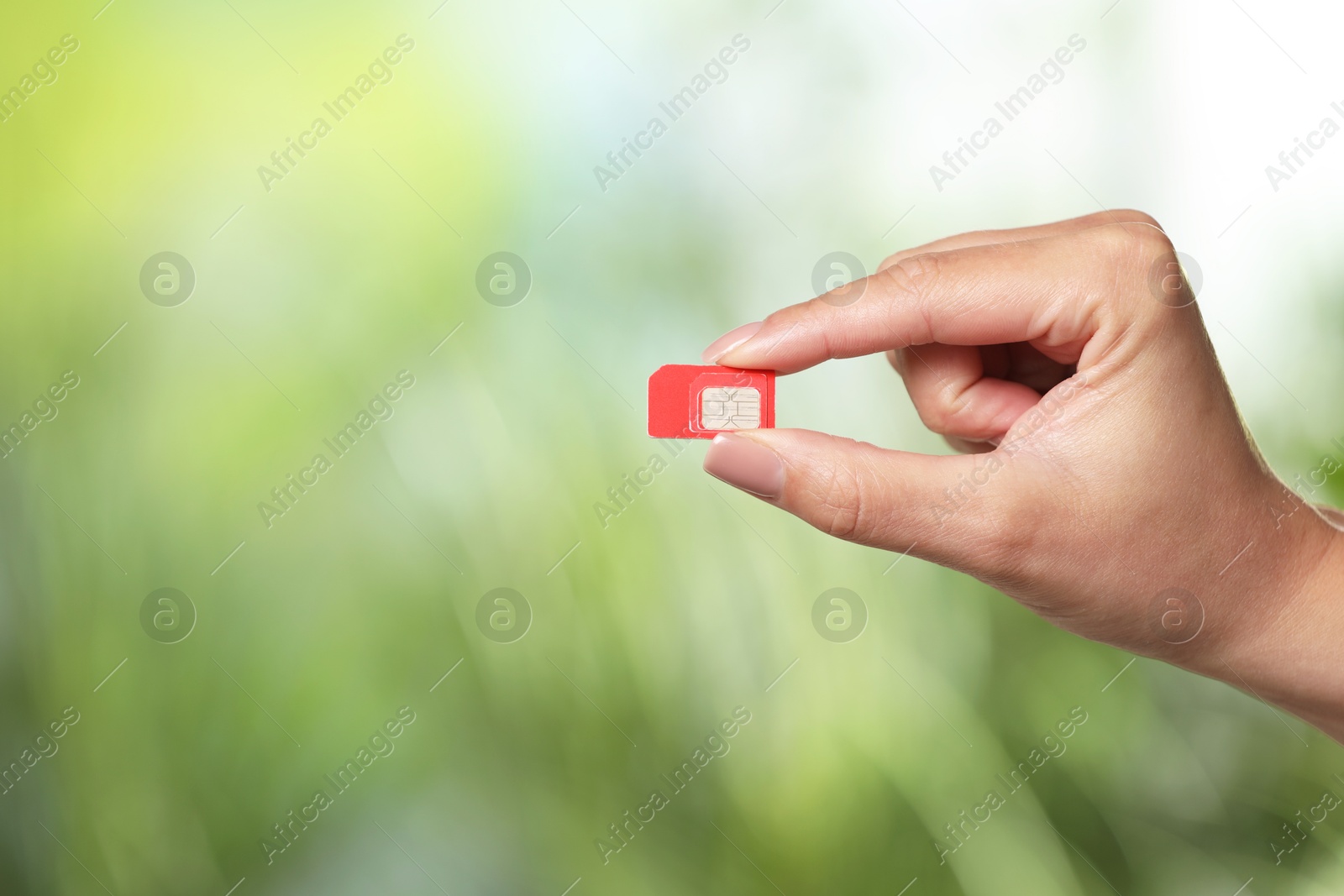 Photo of Woman with SIM card against blurred green background, closeup, Space for text