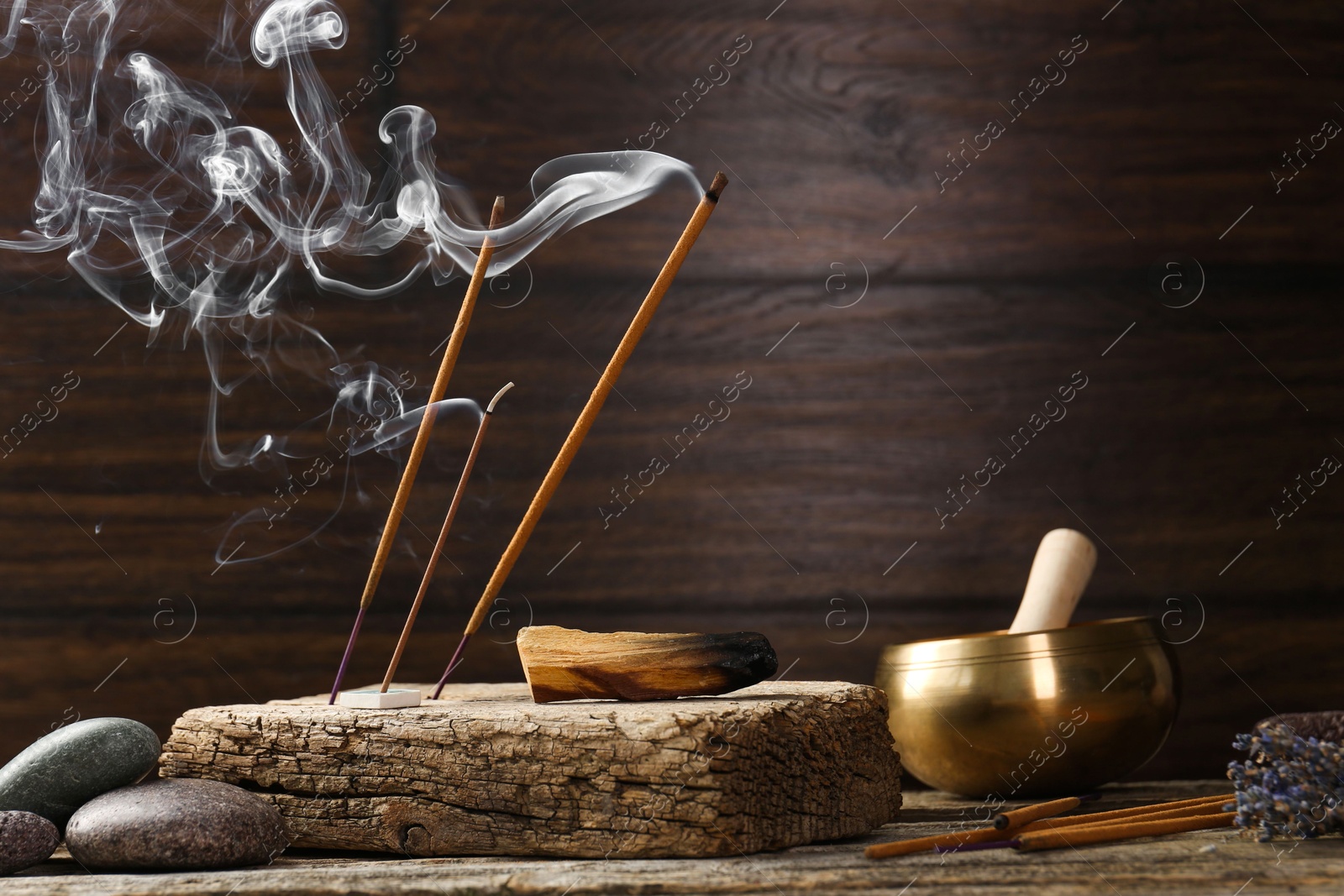 Photo of Aromatic incense sticks smoldering on wooden table