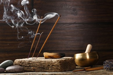 Aromatic incense sticks smoldering on wooden table