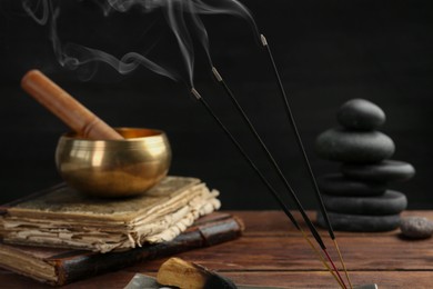 Aromatic incense sticks smoldering on wooden table