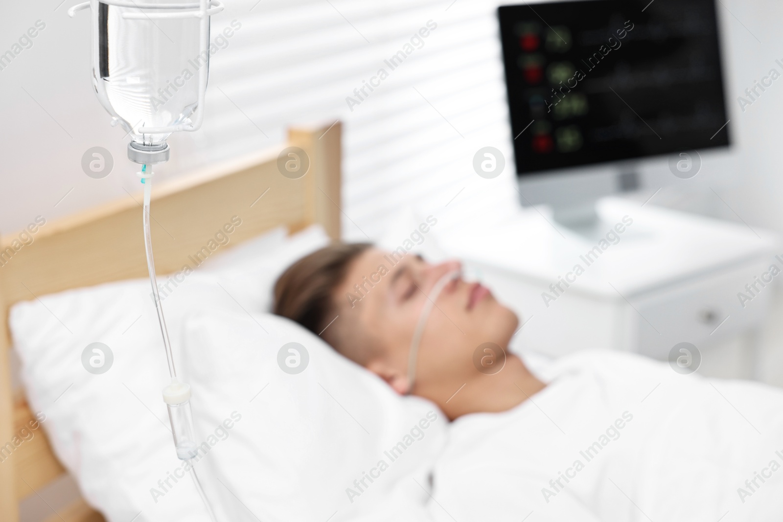 Photo of Coma patient. Young man sleeping in hospital bed, selective focus