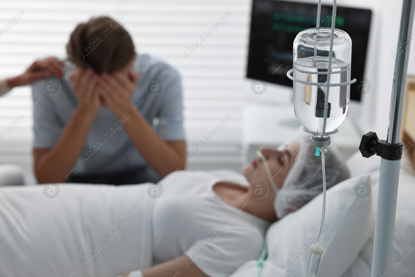 Photo of Coma patient. Sad man near his unconscious wife in hospital, selective focus