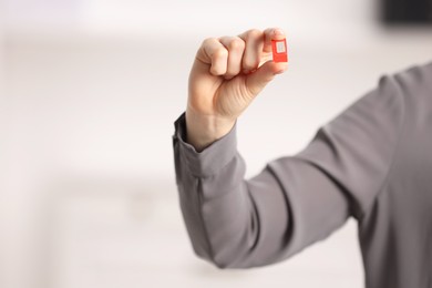 Photo of Woman holding SIM card indoors, closeup. Space for text