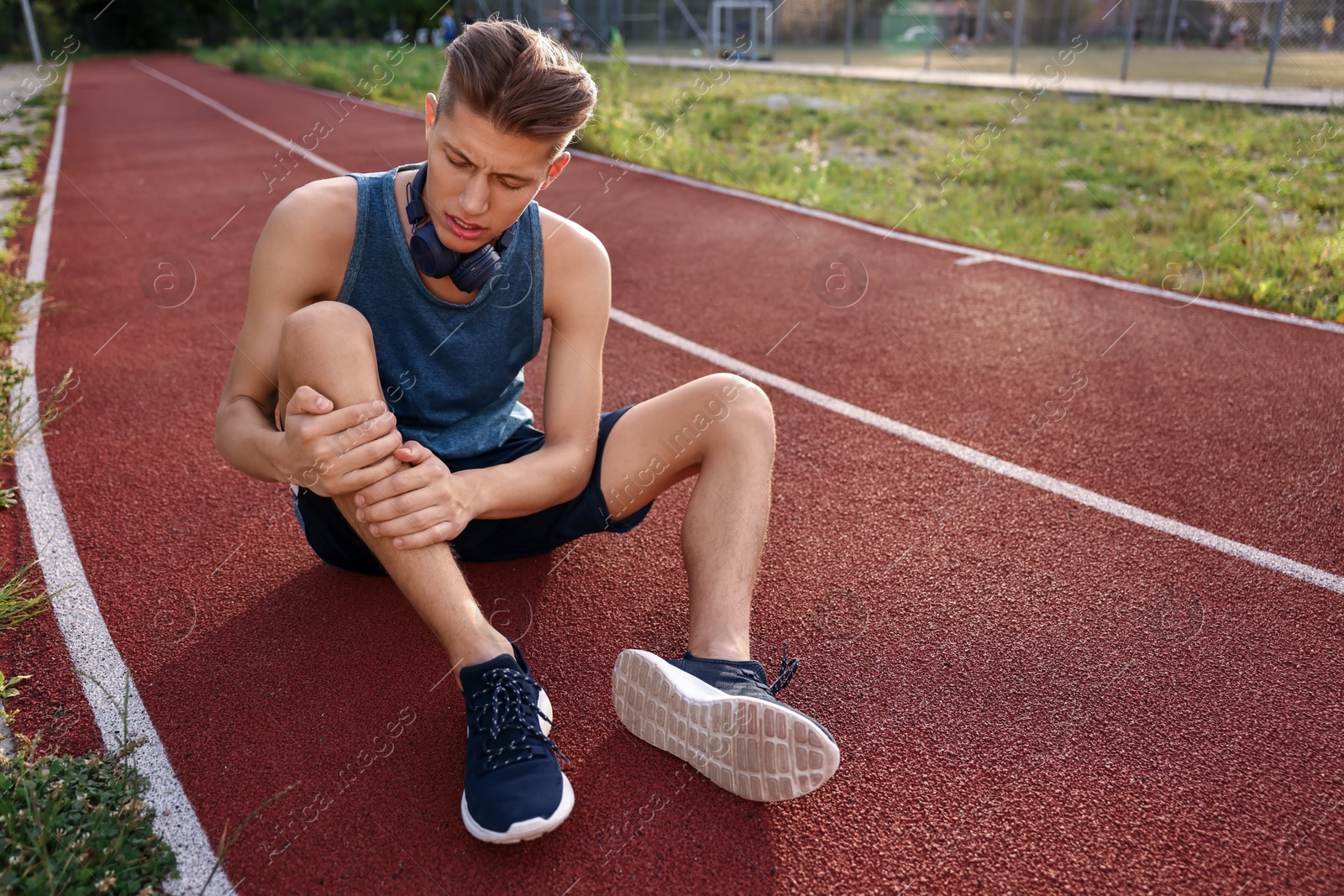 Photo of Sportsman with leg injury at stadium, space for text