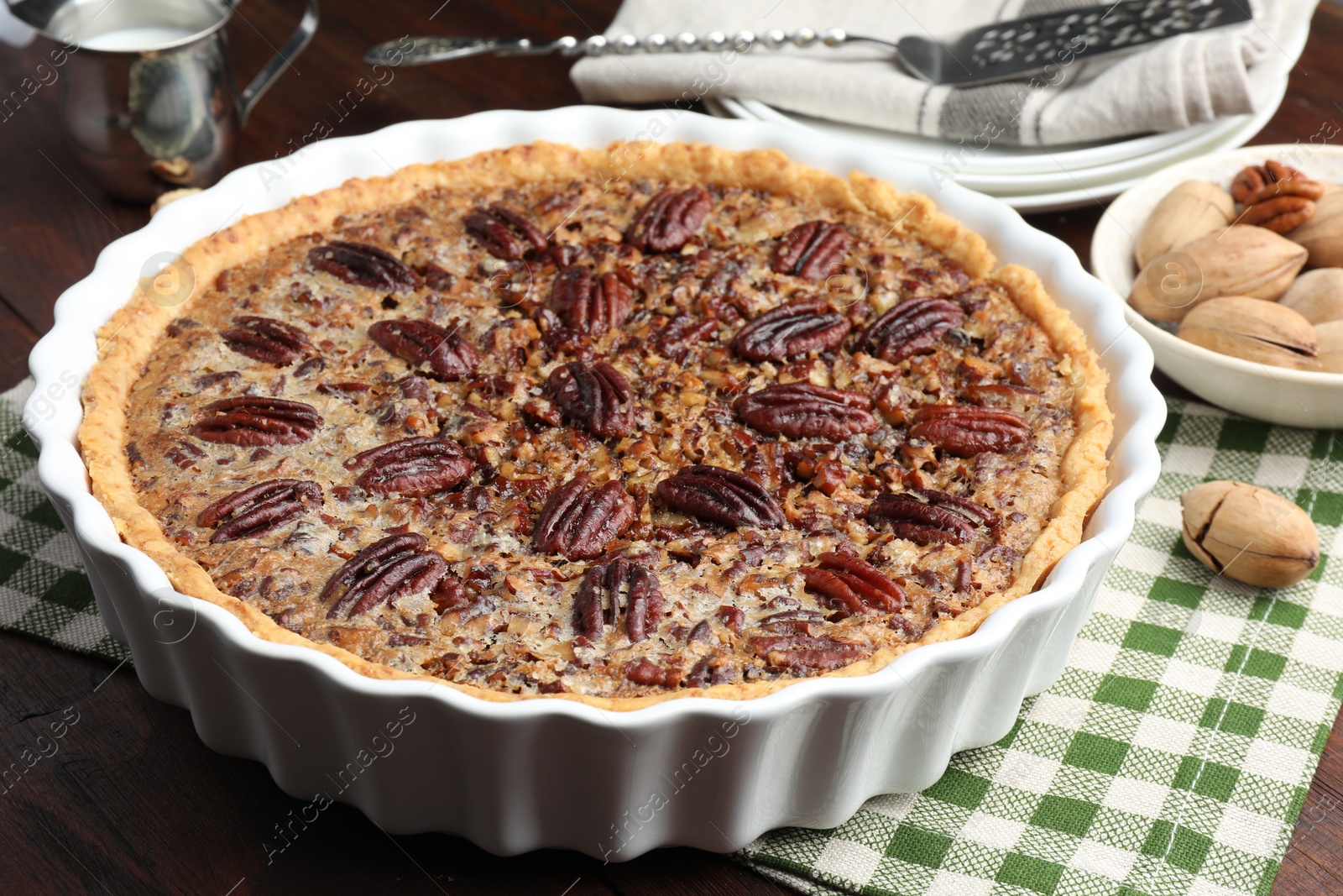 Photo of Delicious pecan pie in baking dish on table, closeup