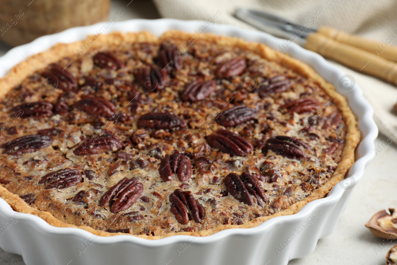 Photo of Delicious pecan pie in baking dish on table, closeup