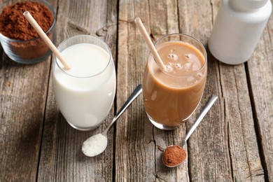 Photo of Delicious protein shakes in glasses and spoons with powder on wooden table