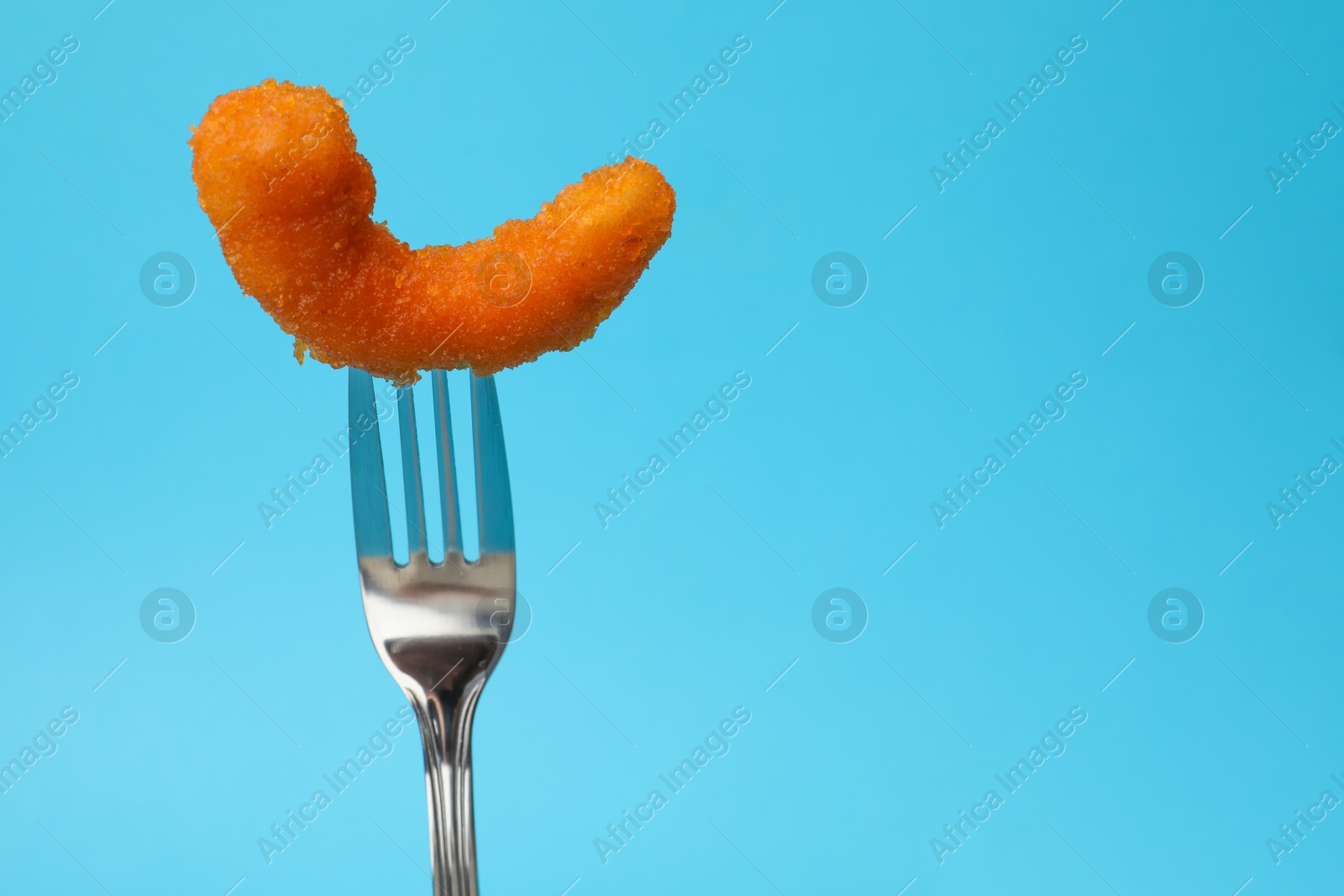 Photo of Fork with tasty fried shrimp on light blue background, closeup. Space for text