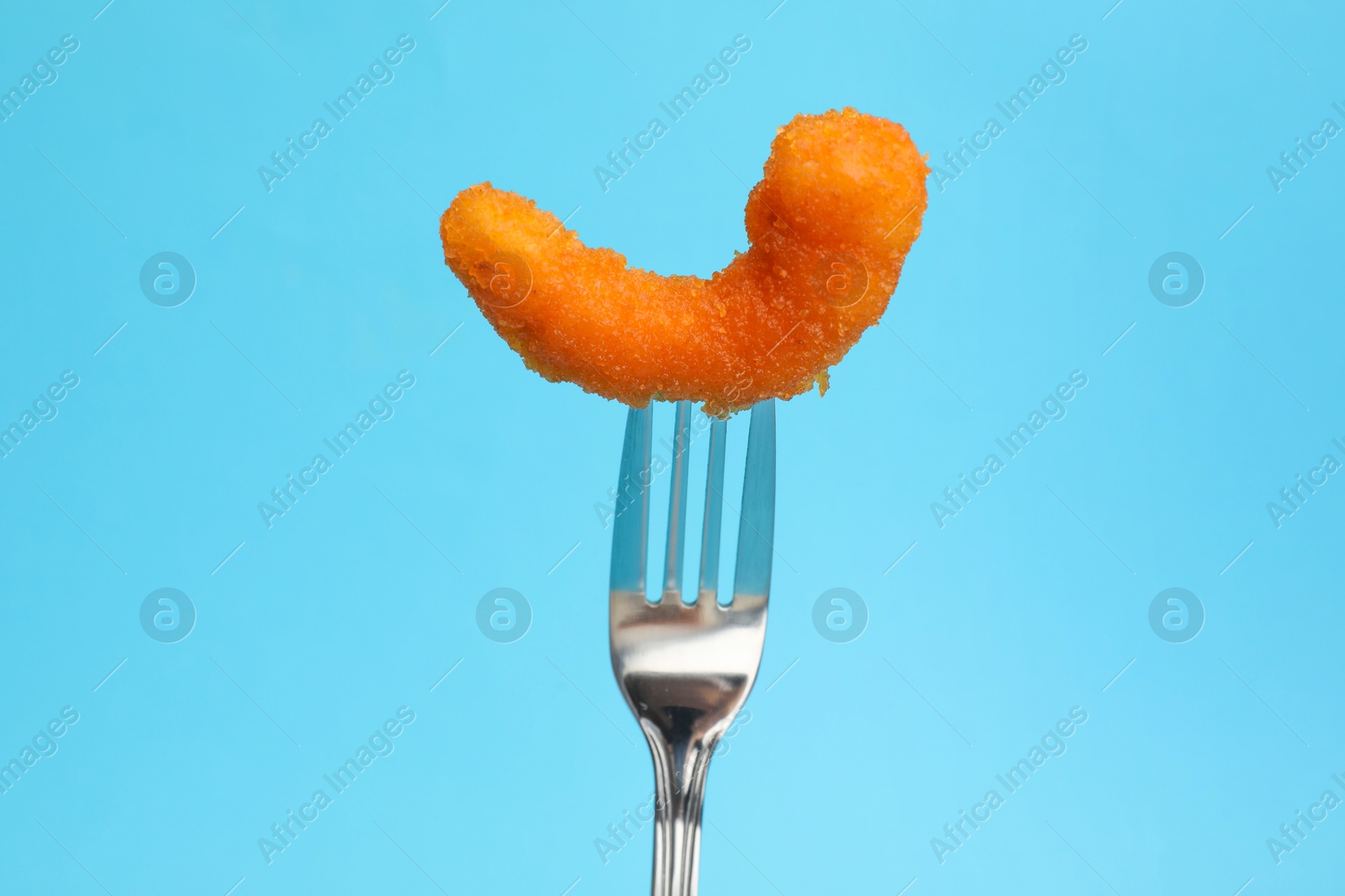 Photo of Fork with tasty fried shrimp on light blue background, closeup