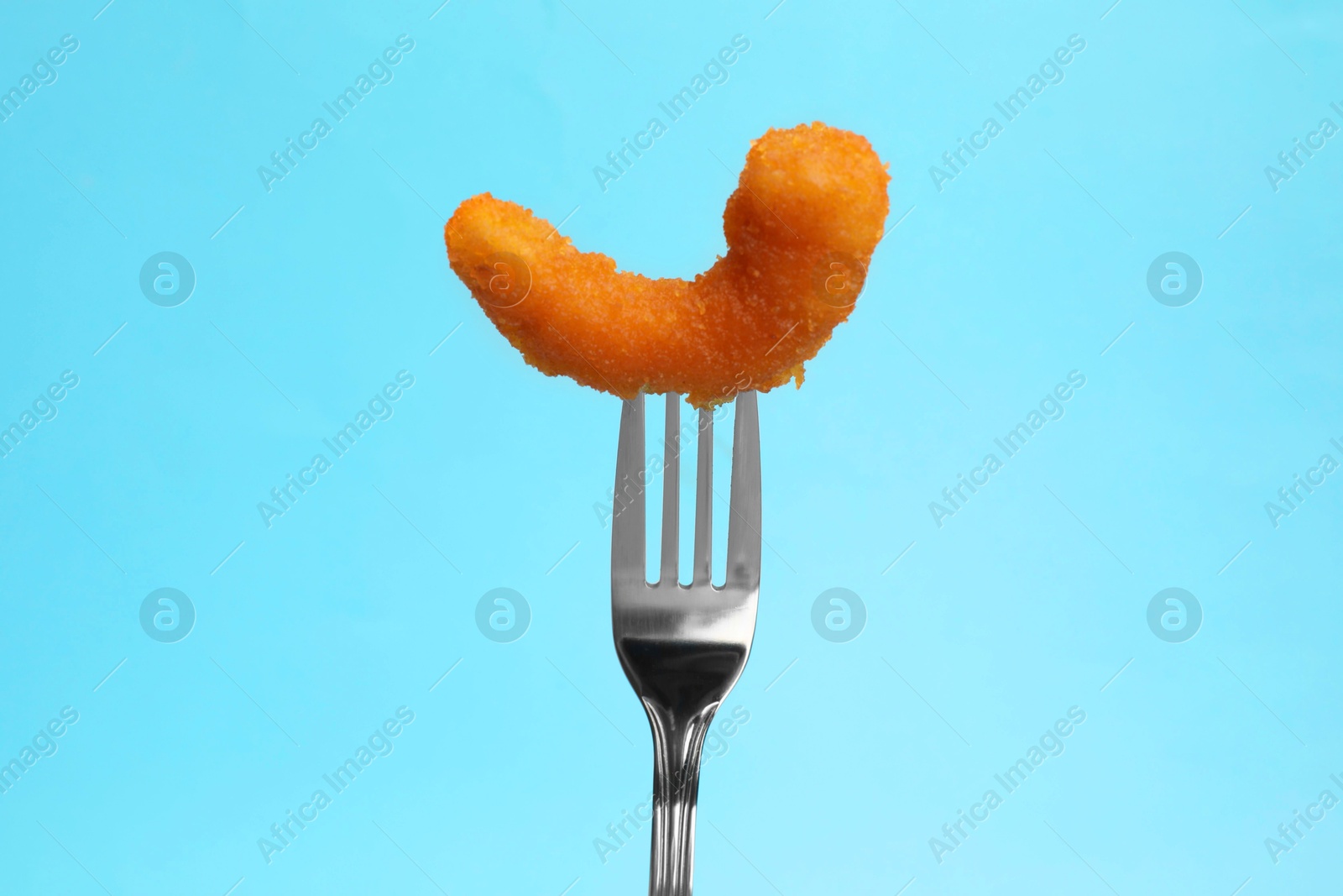 Photo of Fork with tasty fried shrimp on light blue background, closeup