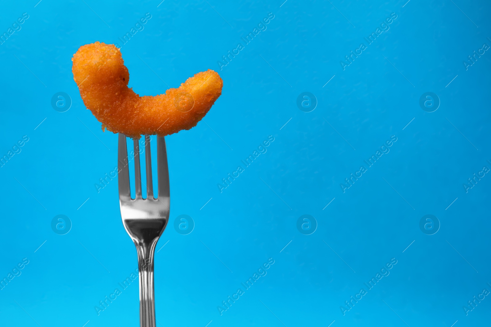 Photo of Fork with tasty fried shrimp on light blue background, closeup. Space for text