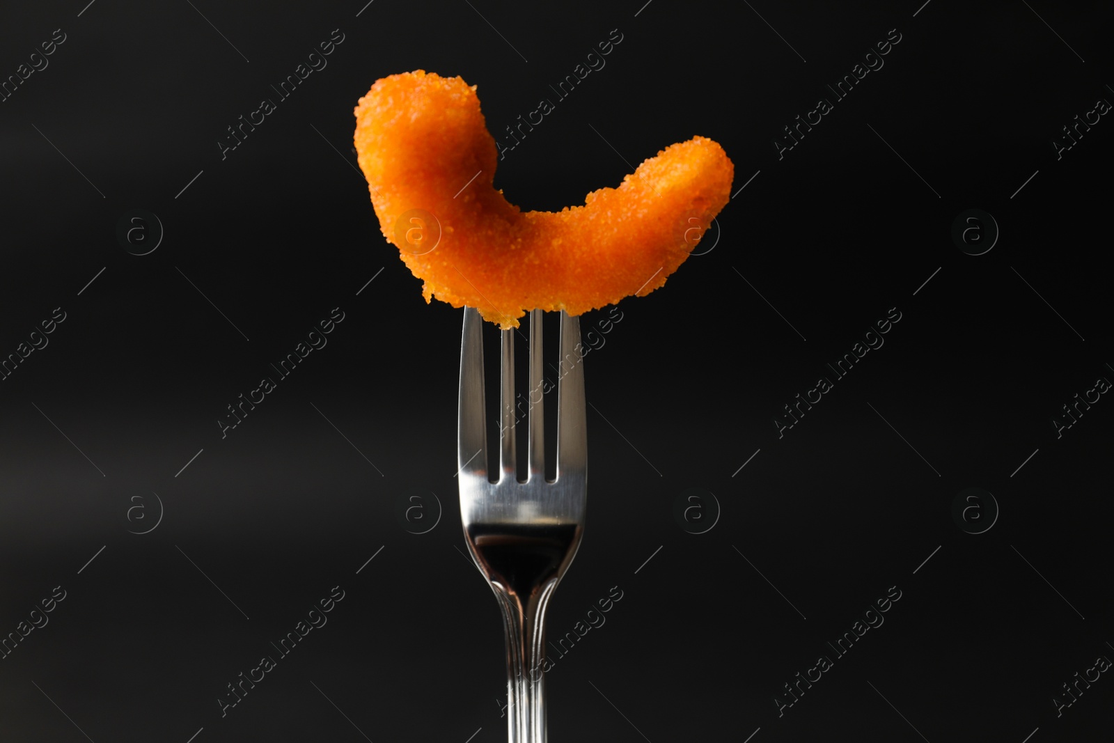 Photo of Fork with tasty fried shrimp on black background, closeup