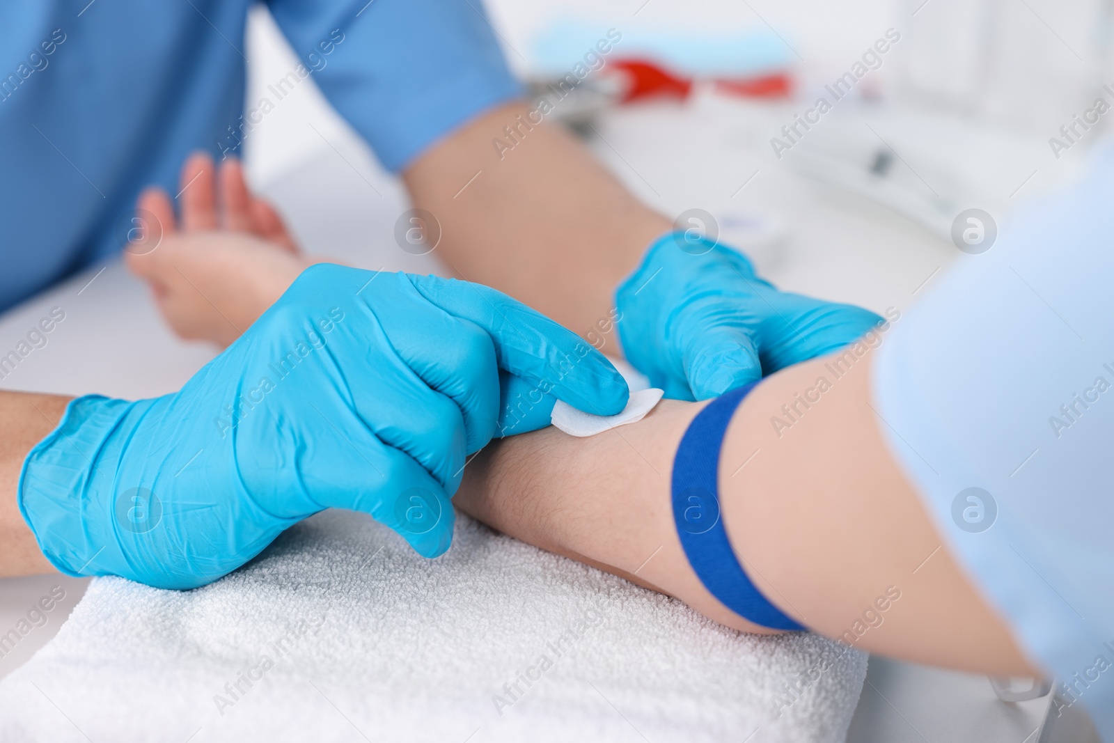 Photo of Nurse inserting IV into arm of patient in hospital, closeup