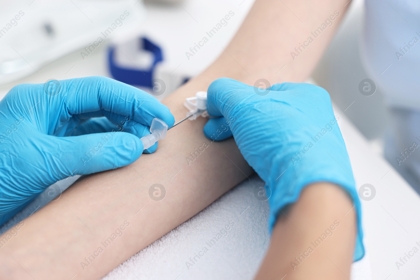 Photo of Nurse inputting catheter for IV drip in patient hand, closeup