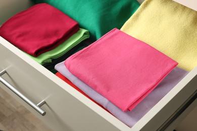 Photo of Chest of drawers with different folded clothes, closeup