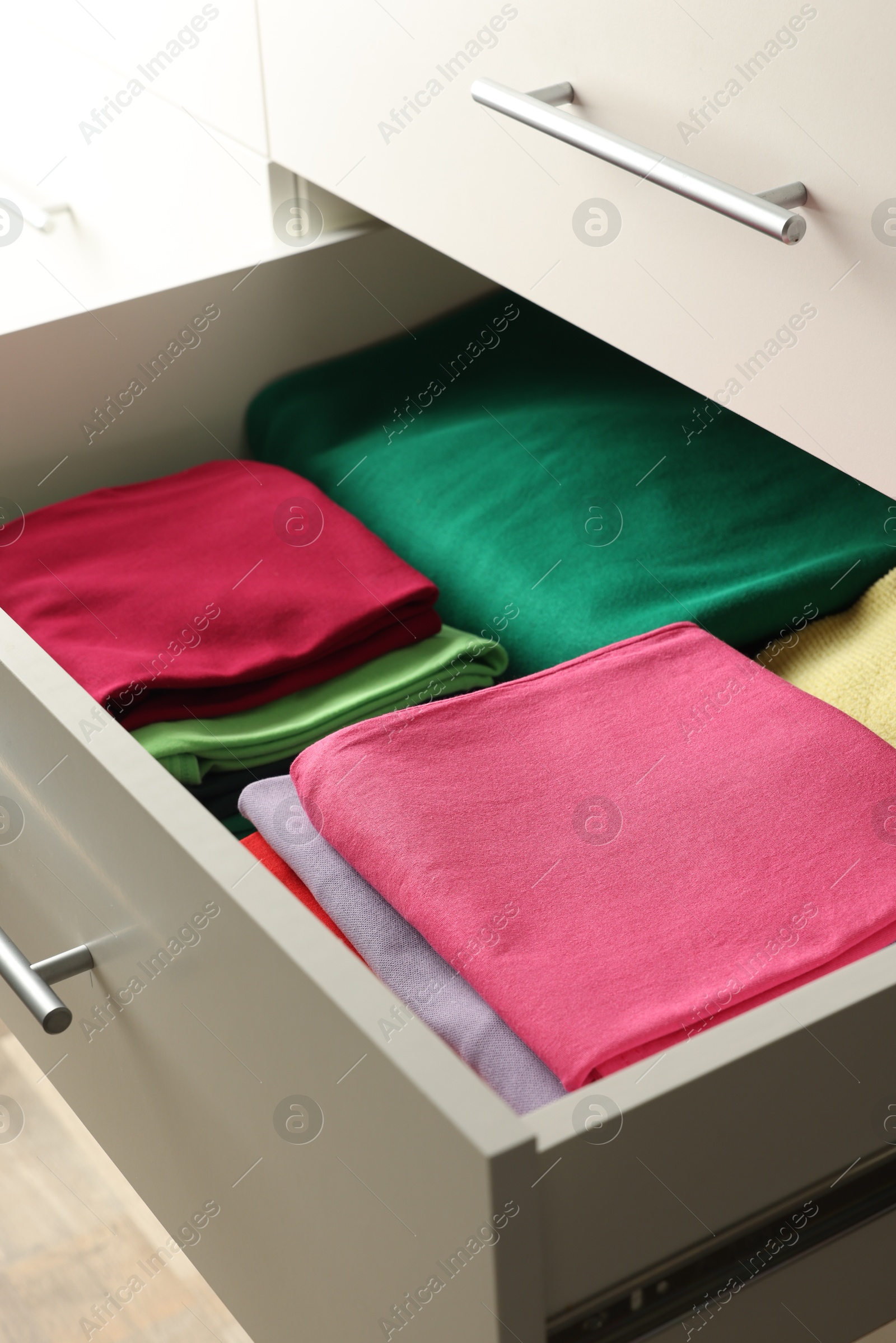 Photo of Chest of drawers with different folded clothes, closeup