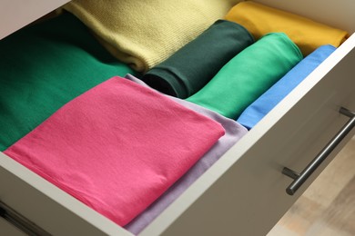 Chest of drawers with different folded clothes, closeup