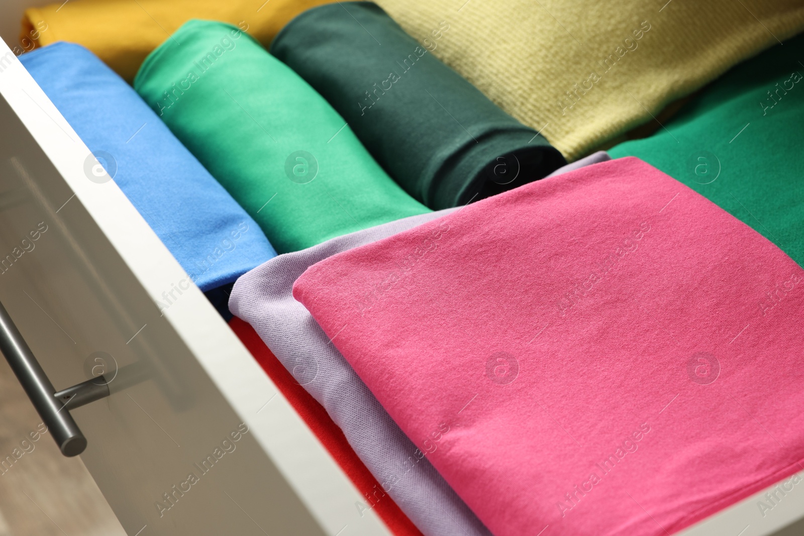 Photo of Chest of drawers with different folded clothes, closeup