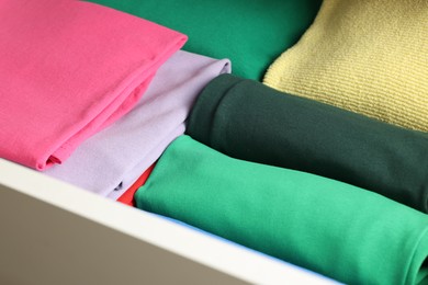 Photo of Chest of drawers with different folded clothes, closeup