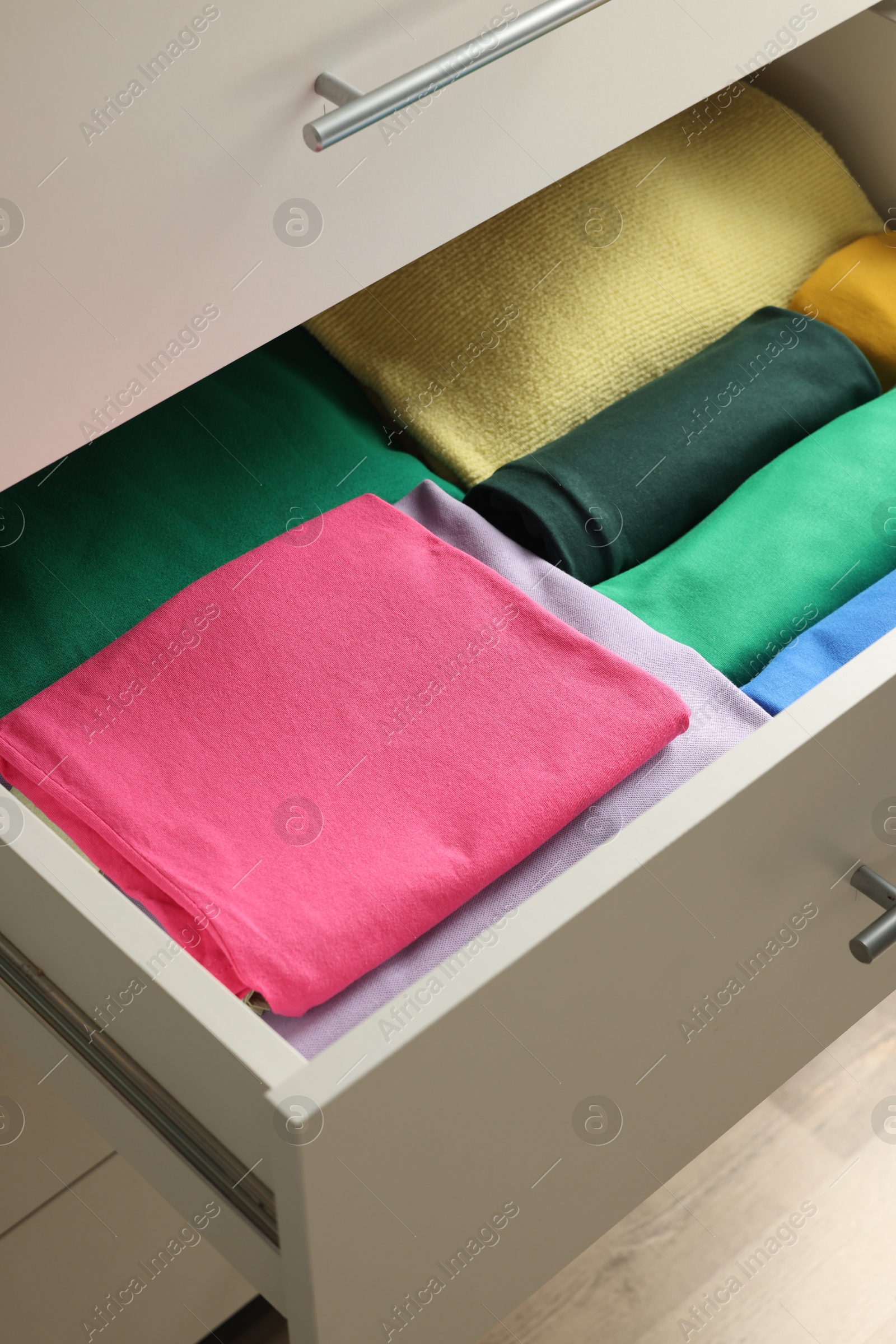 Photo of Chest of drawers with different folded clothes, closeup