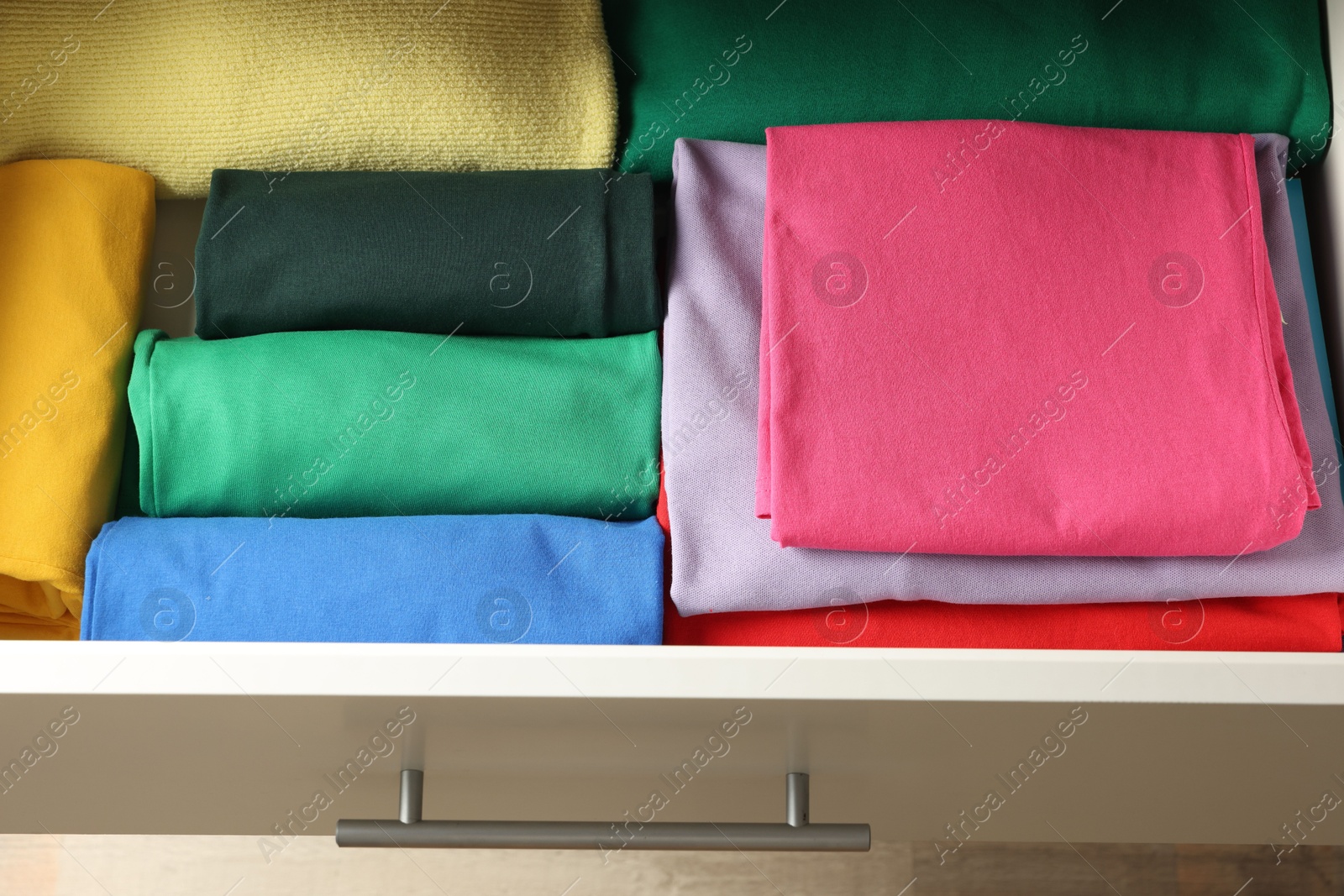 Photo of Chest of drawers with different folded clothes, above view