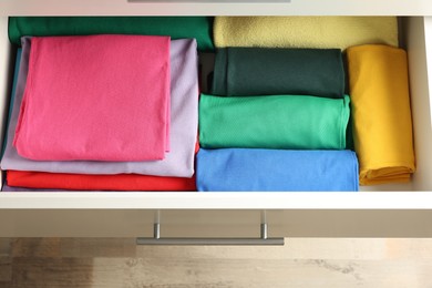 Chest of drawers with different folded clothes, above view