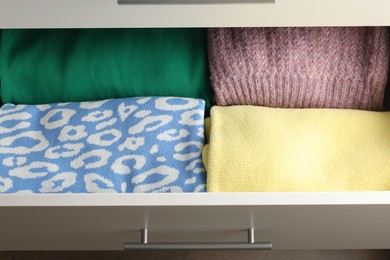 Photo of Chest of drawers with different folded clothes, above view