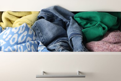 Photo of Cluttered chest of drawers indoors, closeup. Clothes in mess