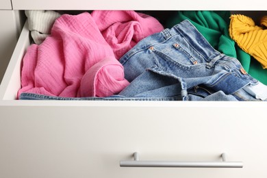 Photo of Cluttered chest of drawers indoors, closeup. Clothes in mess