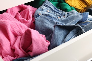 Photo of Cluttered chest of drawers indoors, closeup. Clothes in mess