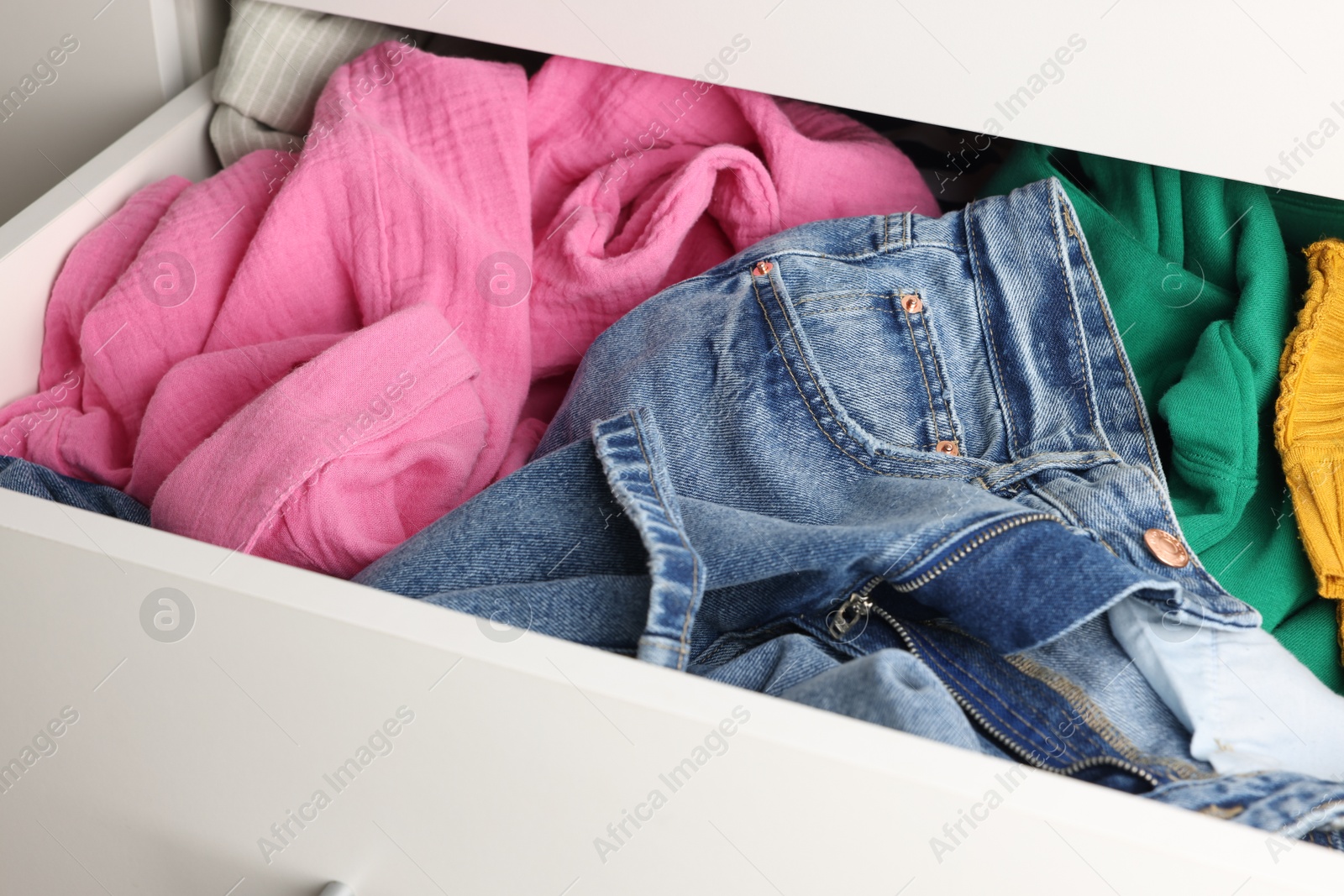 Photo of Cluttered chest of drawers indoors, closeup. Clothes in mess