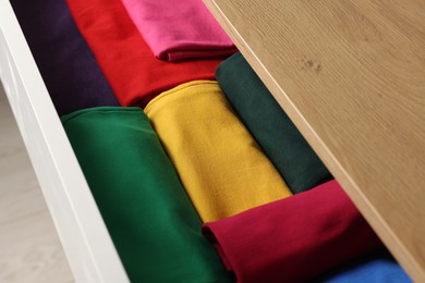 Photo of Chest of drawers with different folded clothes, closeup