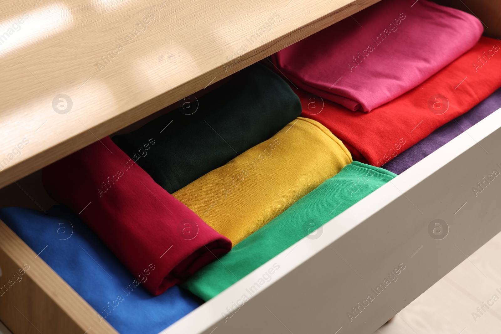 Photo of Chest of drawers with different folded clothes, closeup