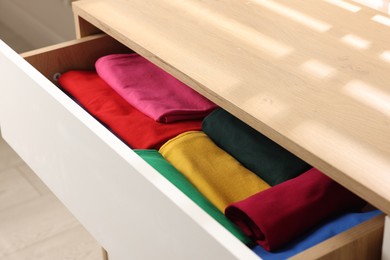 Chest of drawers with different folded clothes, closeup