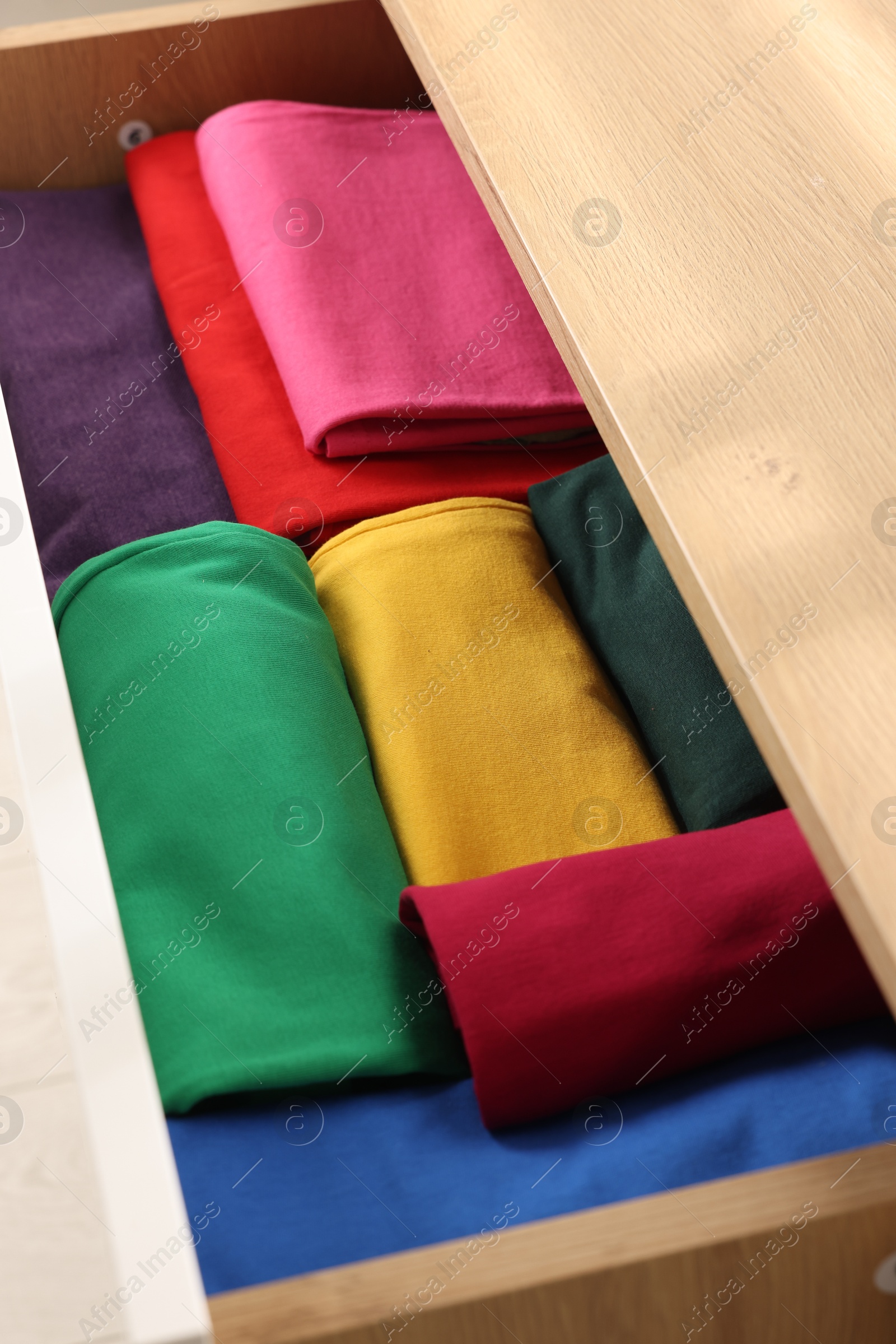 Photo of Chest of drawers with different folded clothes, closeup