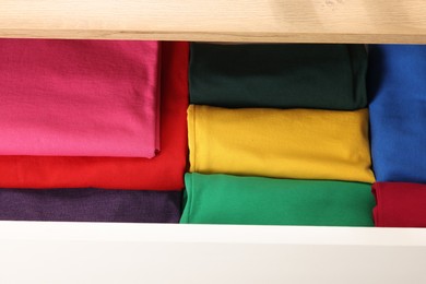 Chest of drawers with different folded clothes, above view