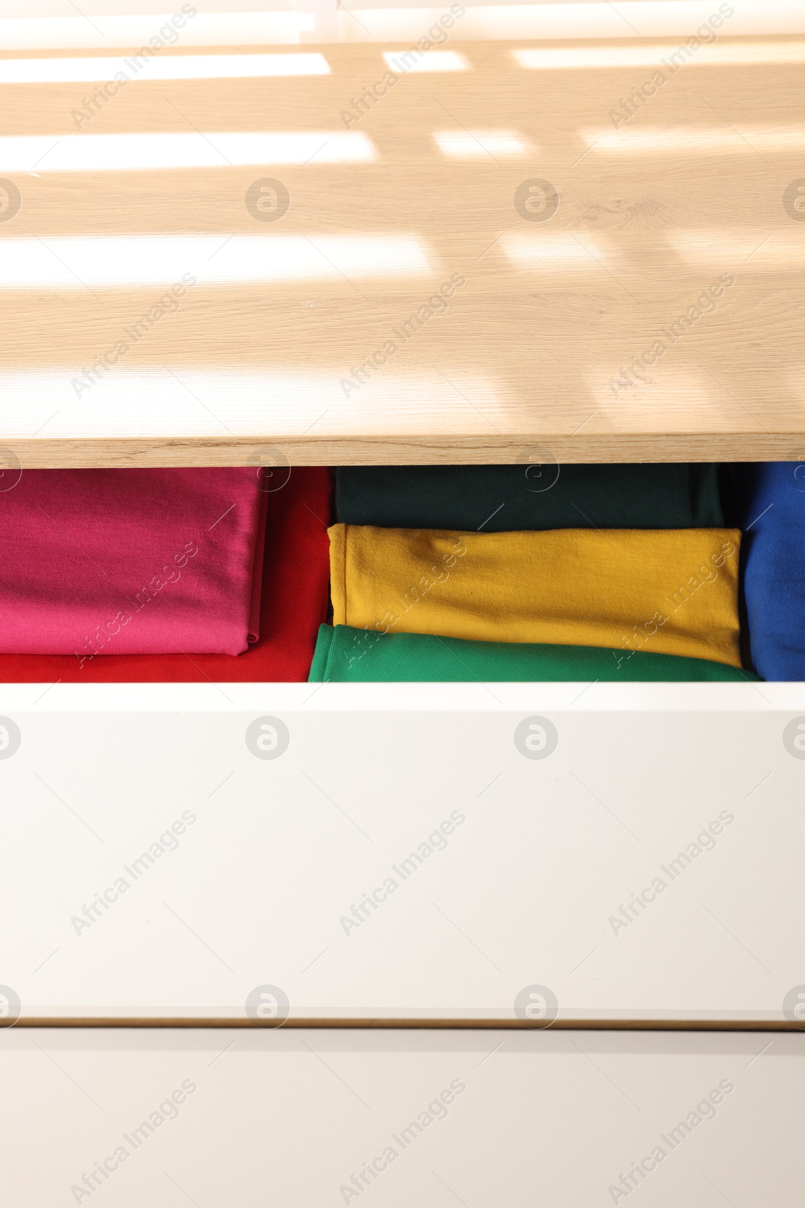 Photo of Chest of drawers with different folded clothes, closeup