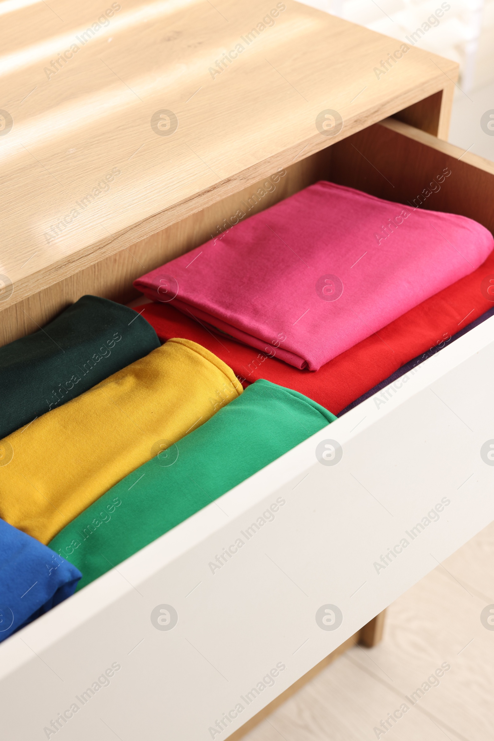 Photo of Chest of drawers with different folded clothes, closeup