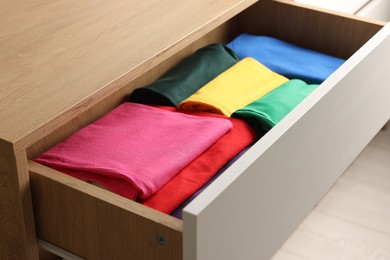 Chest of drawers with different folded clothes, closeup