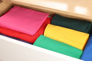 Photo of Chest of drawers with different folded clothes, closeup