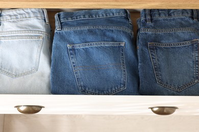 Chest of drawers with different folded jeans, above view