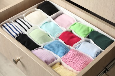 Photo of Chest of drawers with different folded clothes, closeup