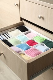 Chest of drawers with different folded clothes, closeup