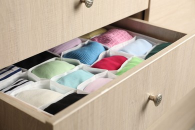 Photo of Chest of drawers with different folded clothes, closeup