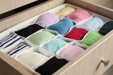 Chest of drawers with different folded clothes, closeup