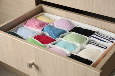 Chest of drawers with different folded clothes, closeup