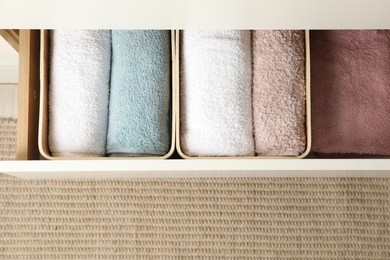 Chest of drawers with different folded clothes indoors, top view