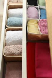 Chest of drawers with different folded clothes, closeup