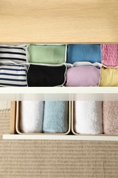 Chest of drawers with different folded clothes, top view